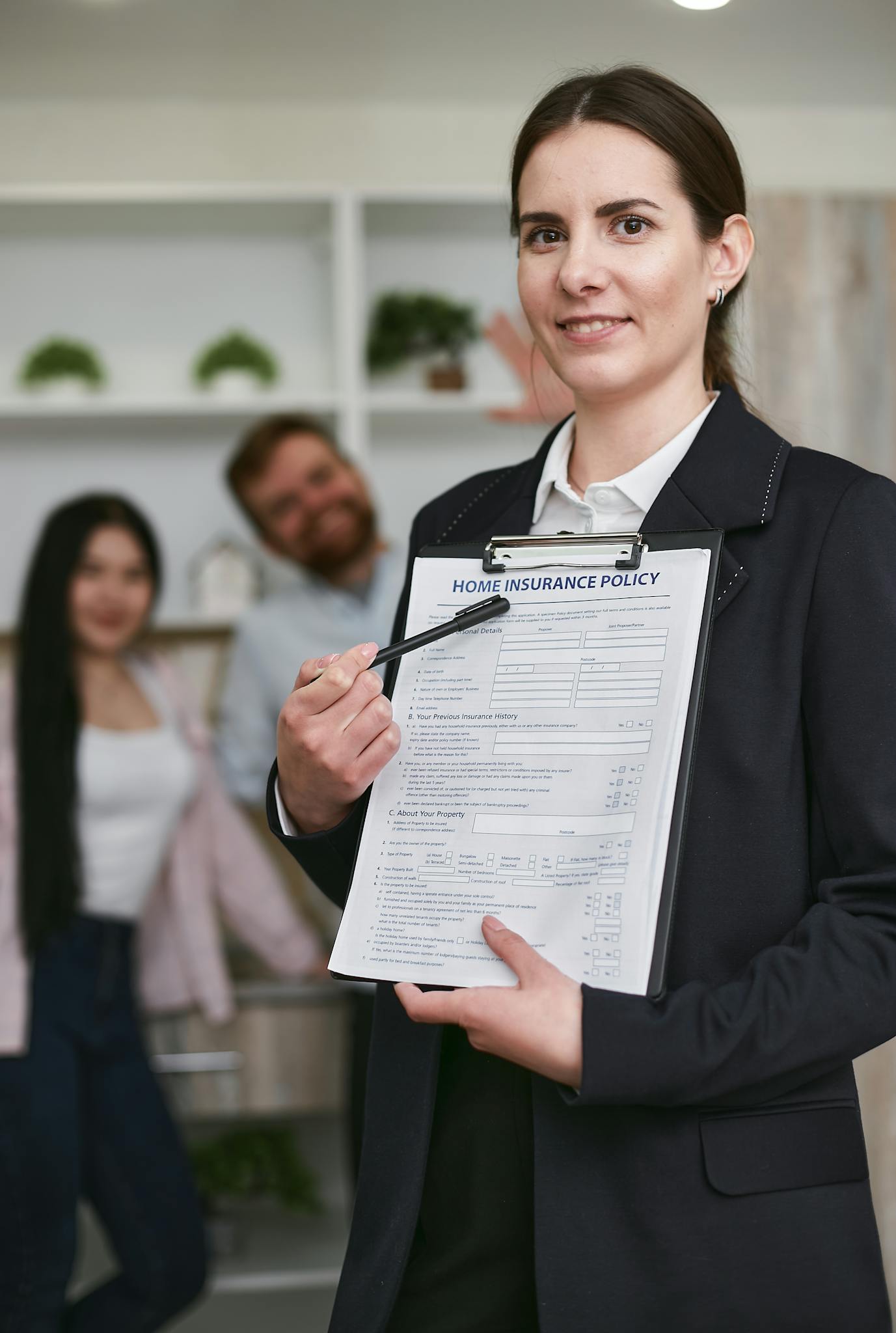 Confident businesswoman presenting a home insurance policy indoors to potential clients.